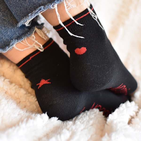 chaussettes dépareillées noires avec un motif coeur et un motif étoile